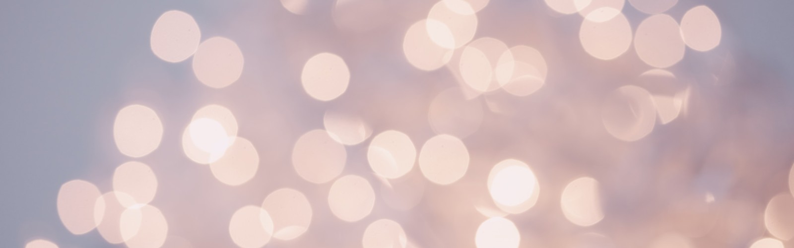 The image shows a soft-focus bokeh effect with numerous out-of-focus, circular light spots against a neutral background, creating an abstract look.